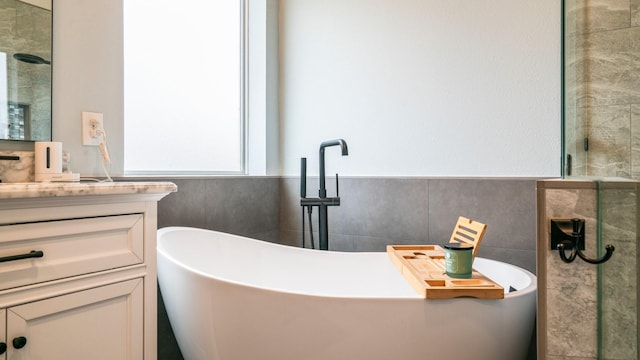 bathroom featuring vanity, plus walk in shower, and tile walls