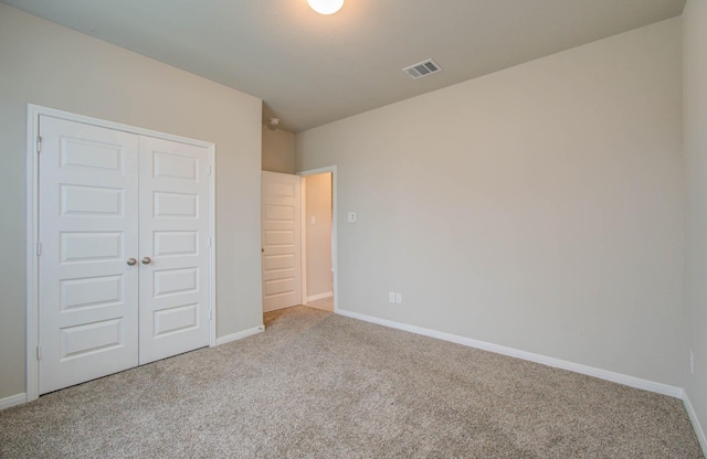 unfurnished bedroom with a closet and carpet flooring