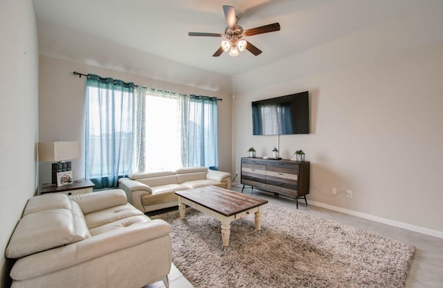 living room with ceiling fan, light tile patterned floors, and lofted ceiling