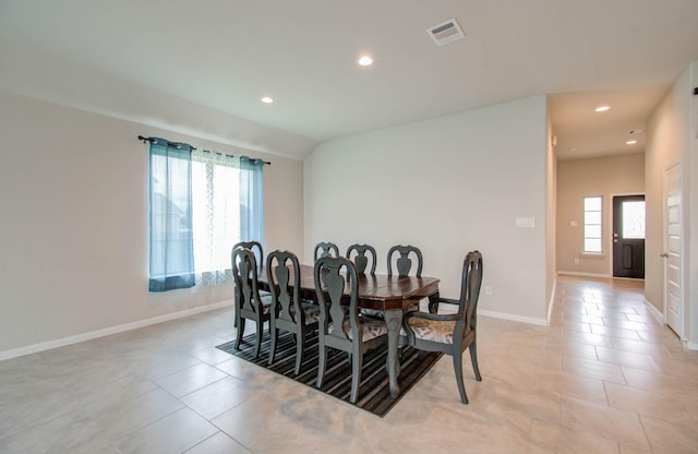 tiled dining space with plenty of natural light and lofted ceiling