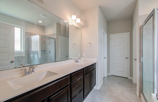 bathroom with tile patterned flooring, walk in shower, and vanity