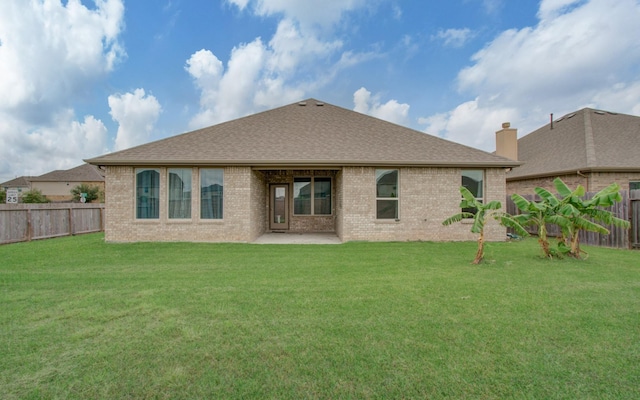 back of house featuring a lawn and a patio