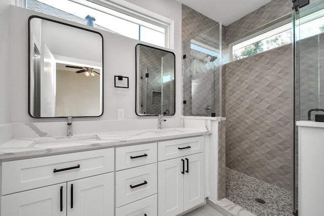 bathroom featuring ceiling fan, vanity, and walk in shower