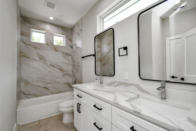 full bathroom featuring tile patterned floors, toilet, vanity, and tiled shower / bath combo