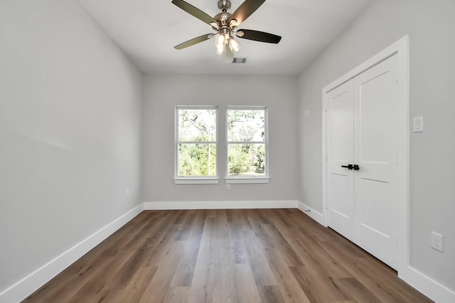 spare room with ceiling fan and dark wood-type flooring