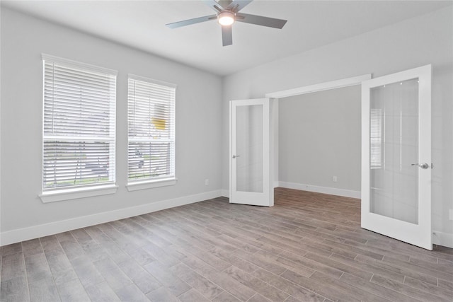 unfurnished bedroom with ceiling fan, baseboards, french doors, and wood finished floors