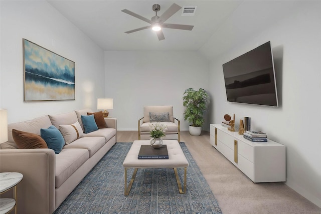 living area featuring light colored carpet, visible vents, baseboards, and a ceiling fan