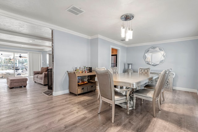 dining space featuring ornamental molding and wood-type flooring