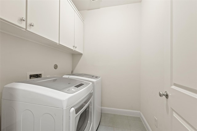 clothes washing area featuring cabinets and washer and dryer