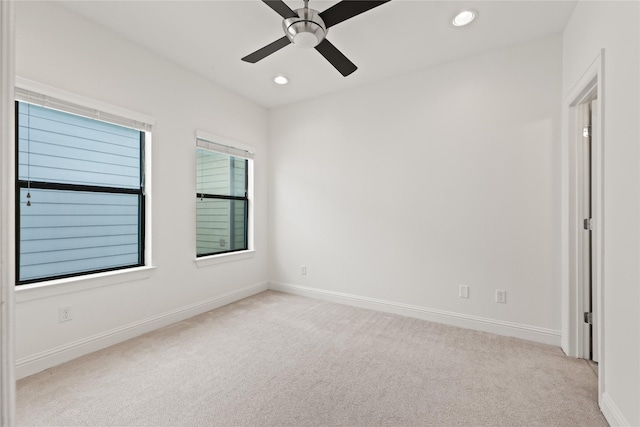 carpeted spare room featuring ceiling fan