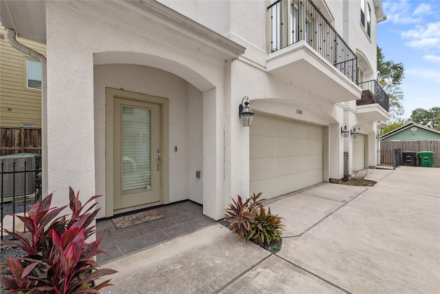 entrance to property featuring a balcony and a garage