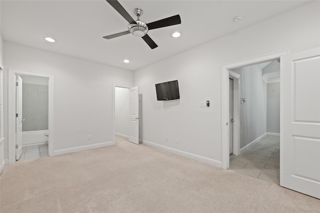 unfurnished bedroom with ensuite bathroom, light colored carpet, and ceiling fan