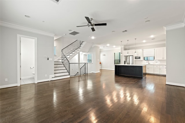 unfurnished living room with crown molding, ceiling fan, and dark hardwood / wood-style floors