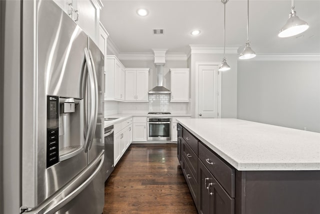 kitchen with decorative light fixtures, appliances with stainless steel finishes, a kitchen island, white cabinets, and backsplash