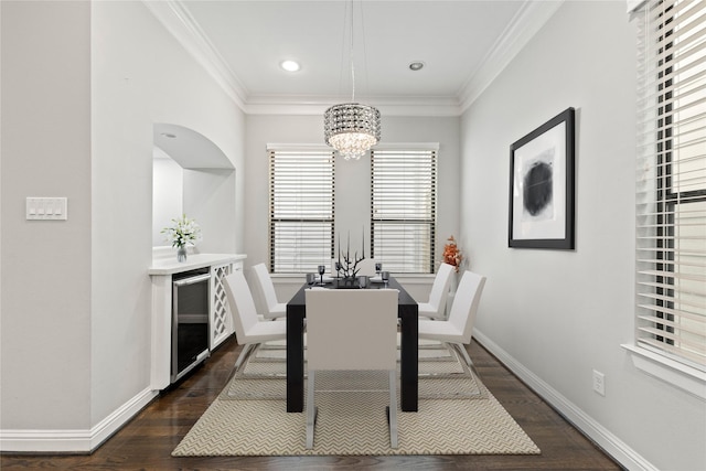 dining area with wine cooler, a notable chandelier, ornamental molding, and dark hardwood / wood-style floors