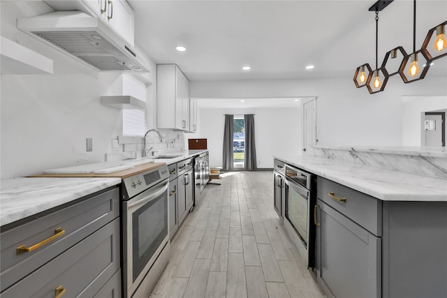 kitchen featuring white cabinetry, electric range, wall chimney range hood, and gray cabinetry