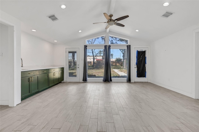 unfurnished living room featuring ceiling fan, sink, and vaulted ceiling