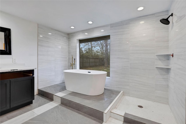 bathroom featuring vanity, tile walls, and plus walk in shower