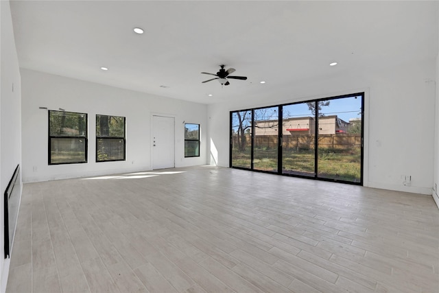 unfurnished living room featuring ceiling fan and light hardwood / wood-style floors