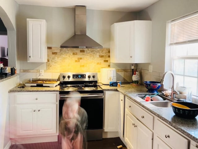 kitchen featuring white cabinetry, sink, stainless steel range with electric stovetop, and wall chimney exhaust hood