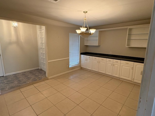 unfurnished dining area featuring light tile patterned floors and a notable chandelier