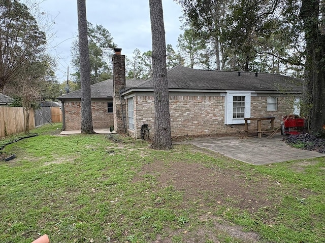 rear view of house featuring a yard and a patio