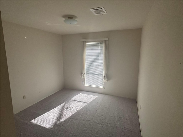 empty room with carpet floors and visible vents