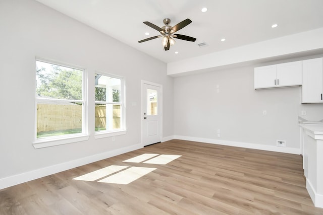 unfurnished living room featuring ceiling fan and light hardwood / wood-style flooring