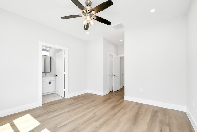 unfurnished bedroom featuring ceiling fan, a closet, ensuite bath, and light wood-type flooring