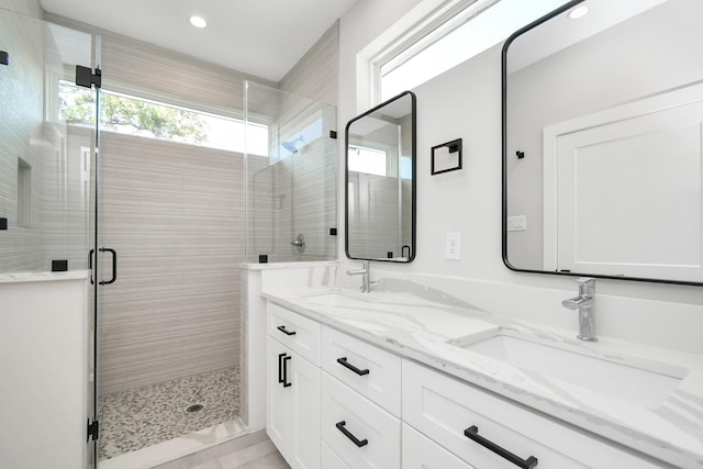 bathroom with a shower with shower door and vanity