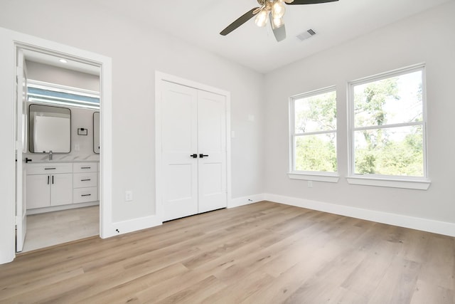 unfurnished bedroom featuring ceiling fan, sink, and light hardwood / wood-style floors