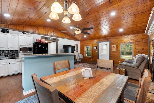 dining space with lofted ceiling, wood ceiling, dark wood-type flooring, wooden walls, and ceiling fan