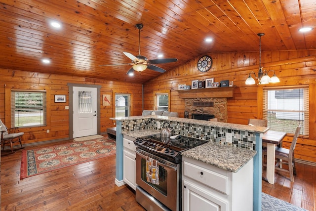 kitchen featuring stainless steel electric stove, decorative light fixtures, white cabinets, and dark hardwood / wood-style flooring