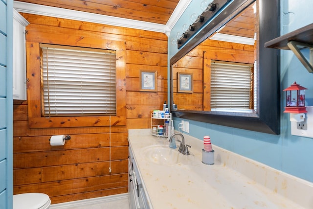 bathroom with toilet, vanity, crown molding, and wooden walls