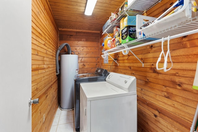 clothes washing area with water heater, wood walls, wooden ceiling, washer and dryer, and light tile patterned flooring