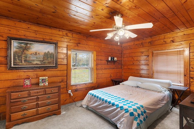 carpeted bedroom featuring ceiling fan, wooden walls, and wooden ceiling