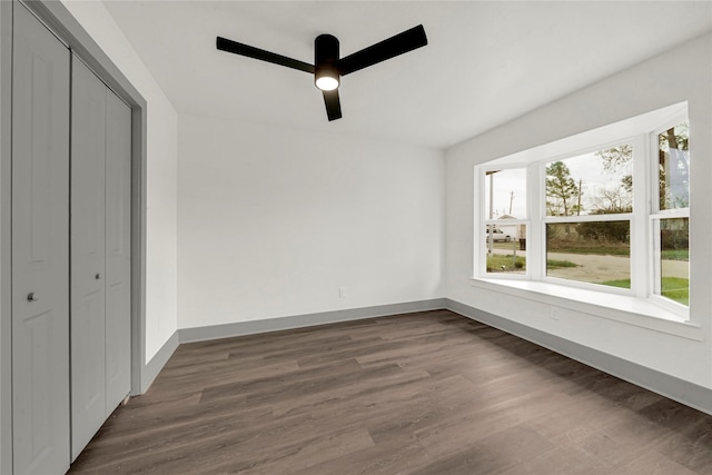 unfurnished bedroom featuring ceiling fan, a closet, and dark wood-type flooring