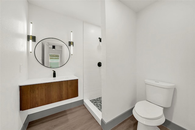 bathroom with walk in shower, vanity, toilet, and hardwood / wood-style flooring