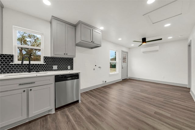 kitchen featuring a wealth of natural light, sink, gray cabinets, a wall mounted AC, and stainless steel dishwasher