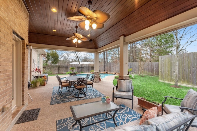 view of patio featuring a fenced in pool, outdoor lounge area, and ceiling fan