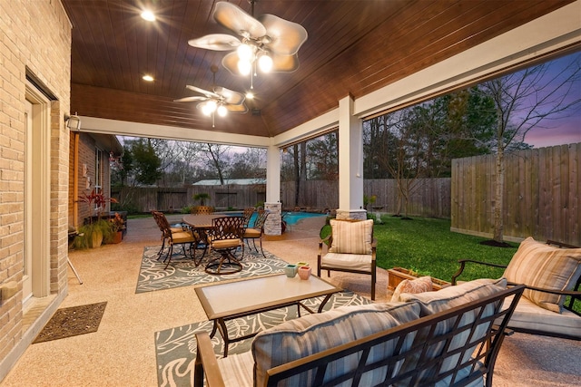 patio terrace at dusk featuring an outdoor living space and ceiling fan