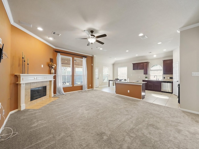 unfurnished living room featuring sink, a healthy amount of sunlight, and light carpet