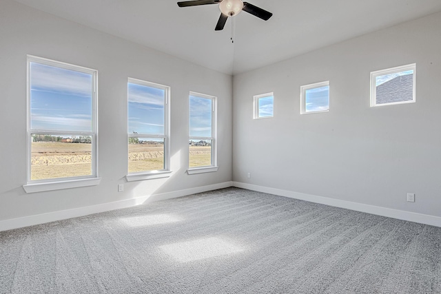 carpeted spare room with ceiling fan and vaulted ceiling