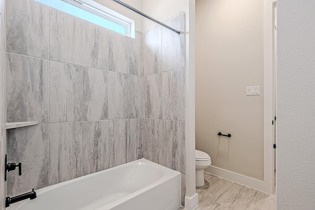 bathroom with tiled shower / bath combo and toilet