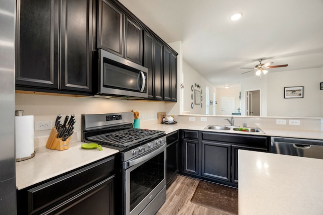 kitchen with ceiling fan, appliances with stainless steel finishes, sink, and hardwood / wood-style floors