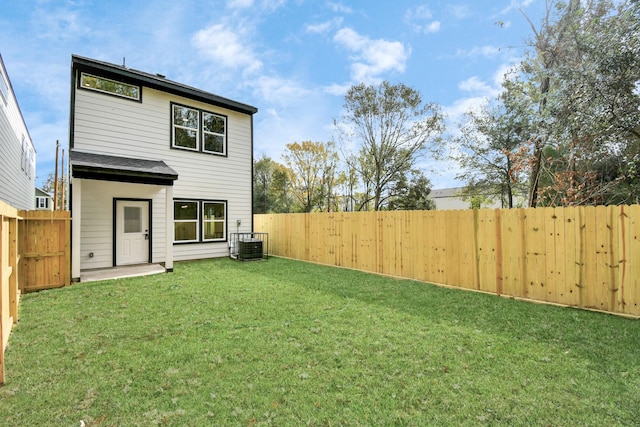 back of house featuring cooling unit and a lawn