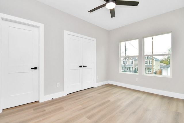 unfurnished bedroom with ceiling fan, a closet, and light wood-type flooring