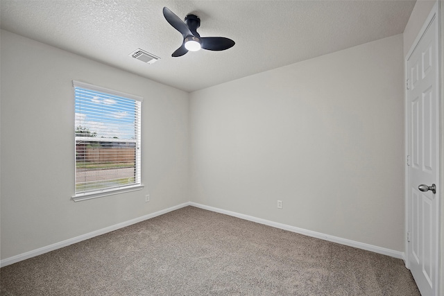 empty room with carpet, a healthy amount of sunlight, ceiling fan, and a textured ceiling