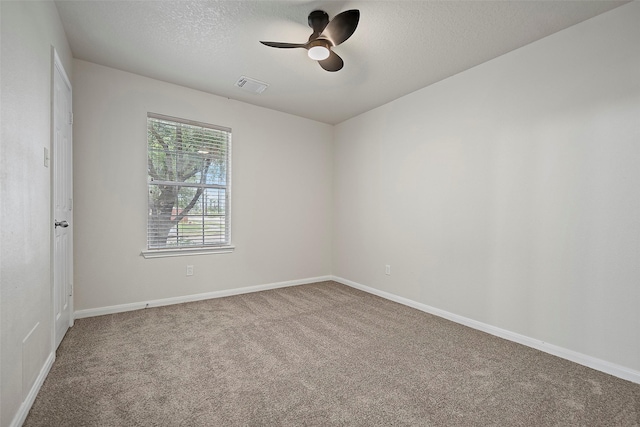 carpeted empty room featuring ceiling fan and a textured ceiling