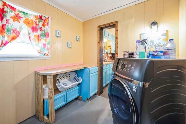 washroom with cabinets, wooden walls, and washer / dryer